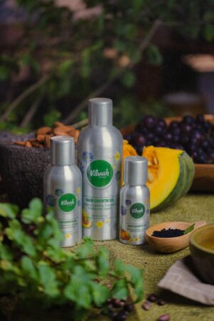 Organic hair growth oil bottles displayed with natural ingredients like seeds and nuts.