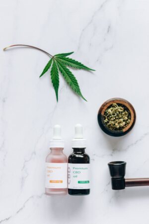 Flat lay of CBD oil bottles and hemp leaf, emphasizing natural wellness products.
