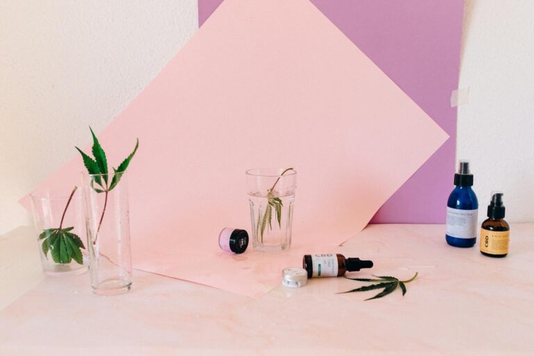 Capelli in autunno: consigli anti caduta 1 Artistic still life of CBD products and cannabis leaves, perfect for wellness content.